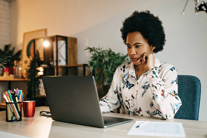 woman looking at laptop on desk