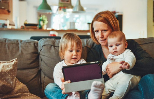 photo of mother and children holding a tablet